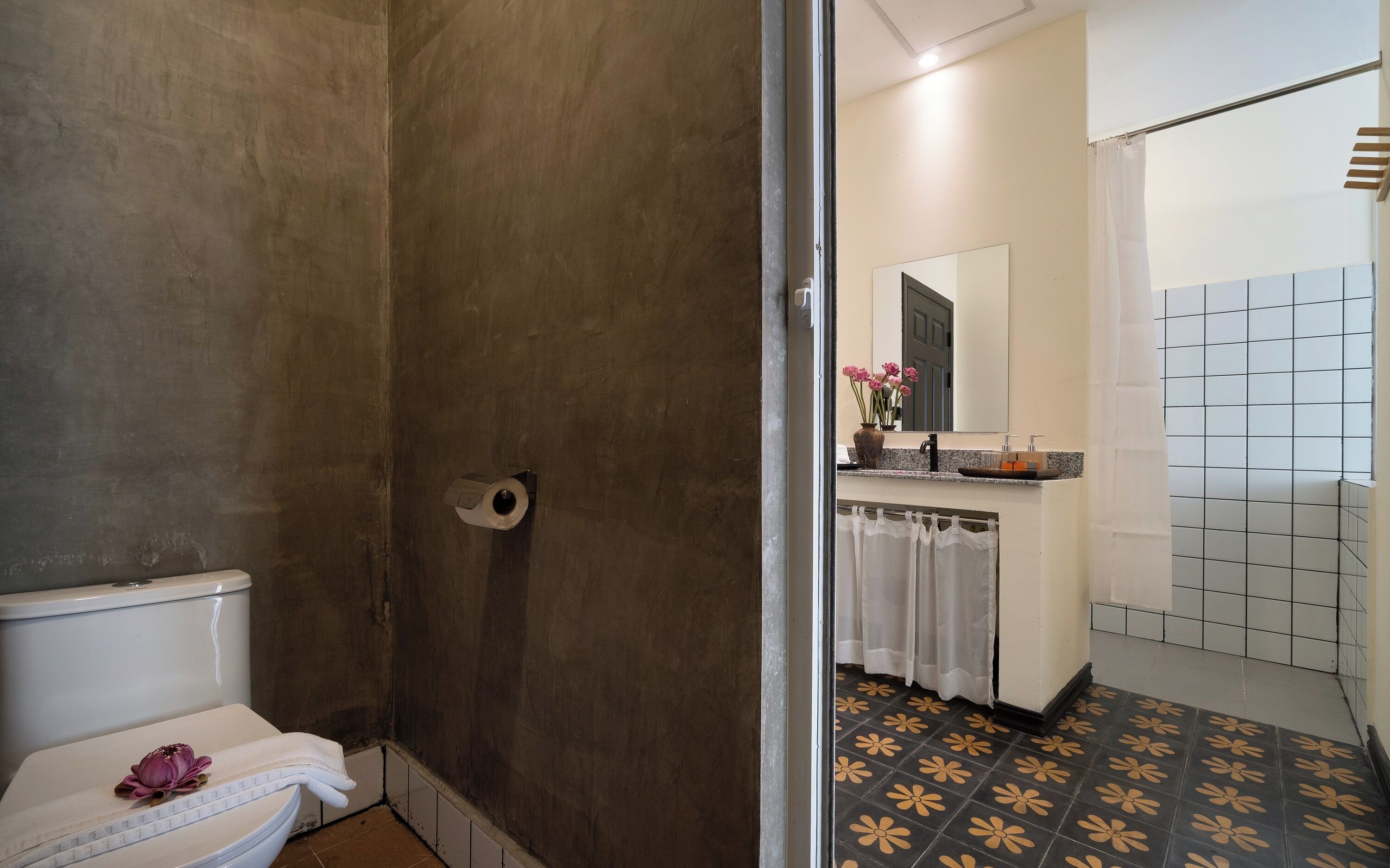 A bathroom with a toilet, shower, and sink.
