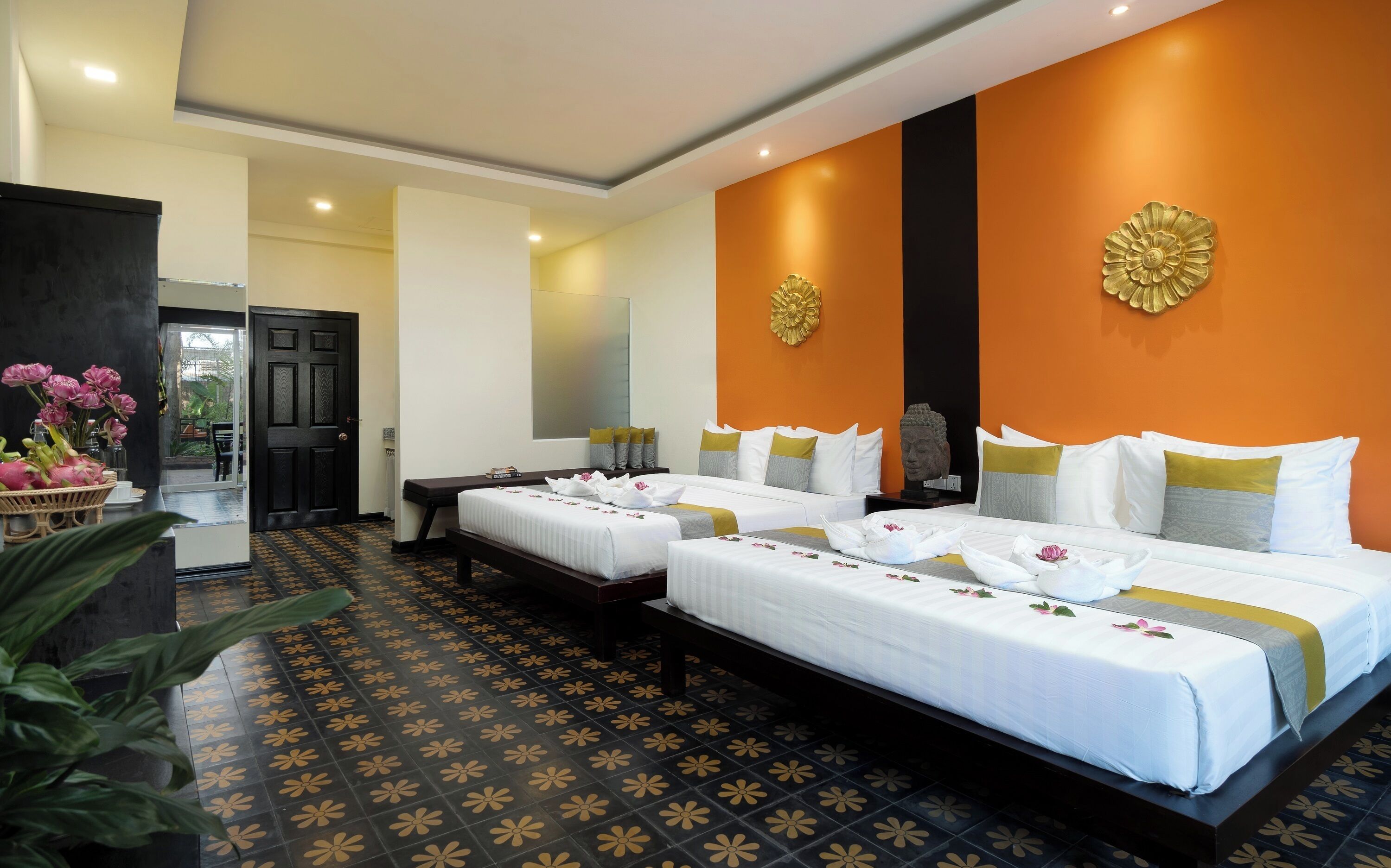 A hotel room with two beds, a large mirror, and a decorative wall piece.
