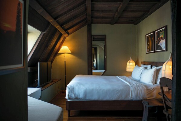 A bedroom with a wooden ceiling, a bed with white bedding, a nightstand, a lamp, and a chair. - Banla Boutique Hotel (Lam Vien - Da Lat)