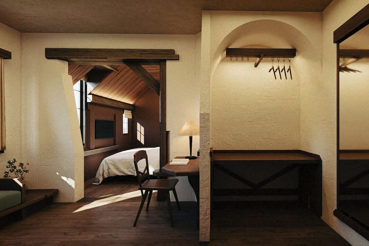 Une pièce confortable avec un lit, un bureau et une chaise. On y trouve également un banc en bois et un porte-manteau suspendu.