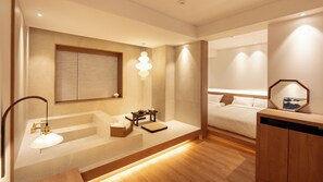 A modern bathroom with a bathtub, a wooden vanity, and a bedside table with a lamp. - Haeundae Toyu Ryokan (Busan)