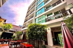 A multi-story building with outdoor seating and a large tree. - Sabaidee@Lao Hotel Vientiane (Vientiane)