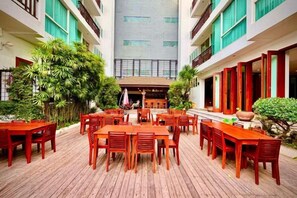 A courtyard with outdoor seating, a central building, and surrounding greenery. - Sabaidee@Lao Hotel Vientiane (Vientiane)
