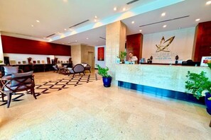 A hotel reception area with a reception desk, seating area, and potted plants. - Sabaidee@Lao Hotel Vientiane (Vientiane)