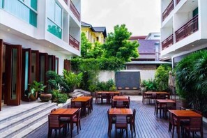 A courtyard with outdoor seating, surrounded by buildings with balconies and windows. - Sabaidee@Lao Hotel Vientiane (Vientiane)