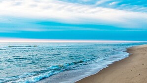 Una playa con olas que acarician suavemente la orilla bajo un cielo despejado.