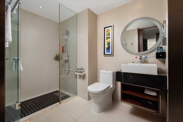 A modern bathroom with a glass-enclosed shower, a toilet, a sink with a marble countertop, and a round mirror. - ECHENG Wuhan Yangjiawan Metro Station (Wuhan)
