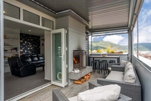 A modern living room with a fireplace, comfortable seating, and a view of the outdoors. - Kinloch Lookout (Kinloch)