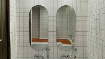 Een badkamer met twee wastafels, een bad en een toilet.