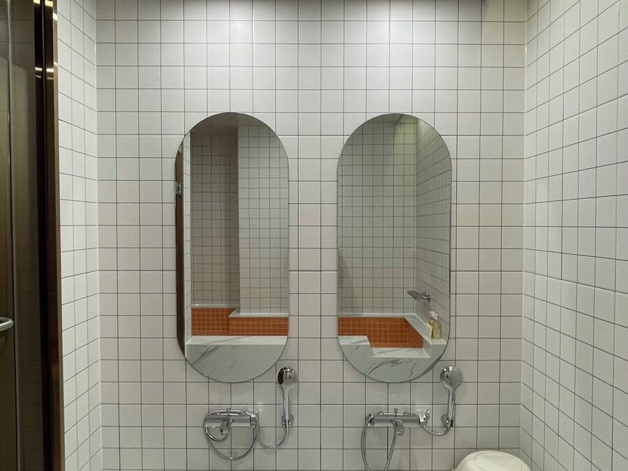 Een badkamer met twee wastafels, een bad en een toilet.