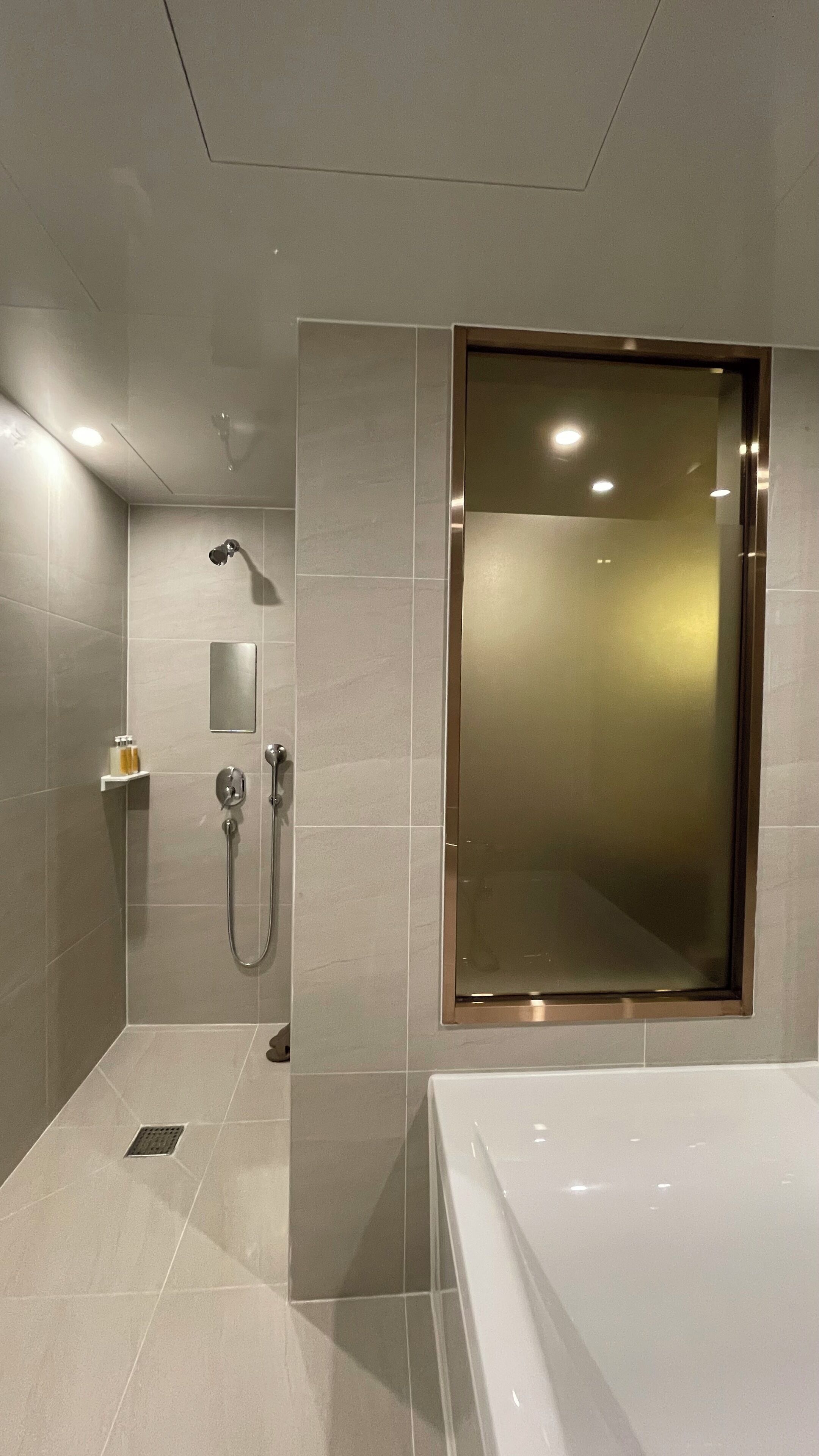 Twin kamer | Badkamer | Een aparte badkuip en douche, een haardroger, pantoffels, handdoeken