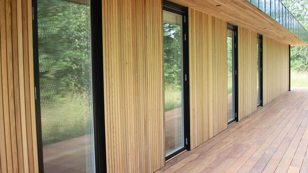 A modern building with vertical wooden paneling and large glass doors. - 5 Star Holiday Home in Aakirkeby (Akirkeby)
