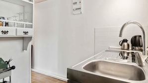 A modern kitchen with a stainless steel sink, a kettle, and a coffee maker on the counter. - 5 Star Holiday Home in Ronne (Ronne)