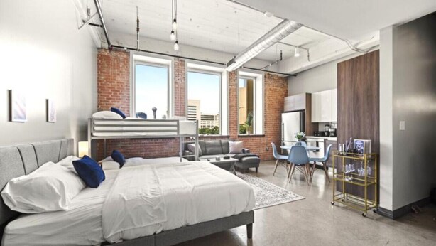 Une chambre d’hôtel moderne avec un grand lit, un bureau et une vue sur la ville.