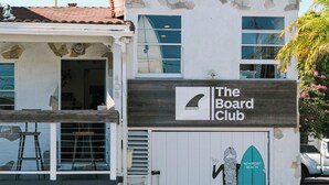 A building with a sign reading "The Board Club" and a surfboard graphic.