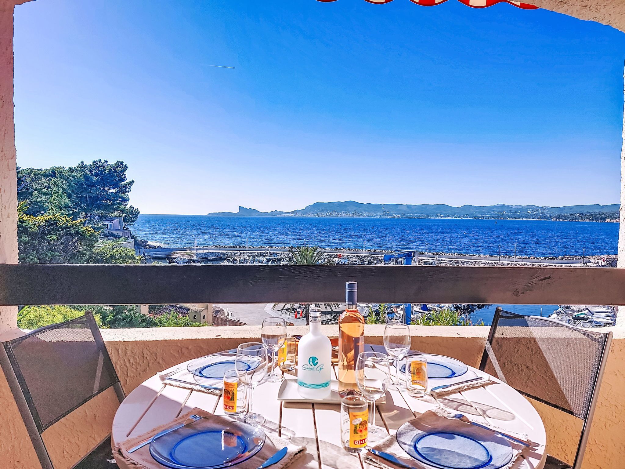 Ein Esstisch mit Blick auf das Meer und sanfte Hügel in der Ferne.