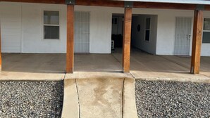 A two-story building with a covered patio area, a garage, and a driveway.