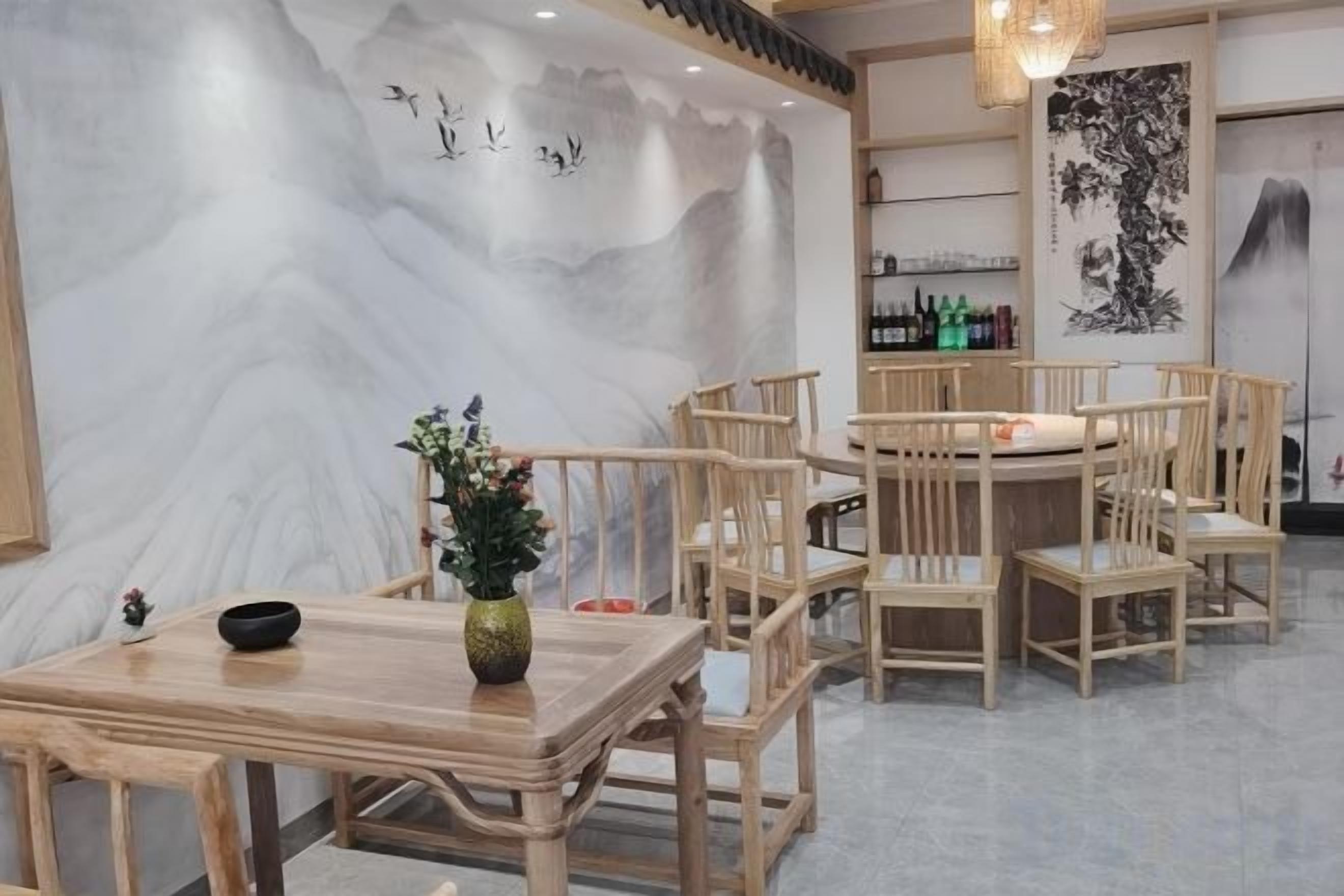 Ein traditioneller Essbereich aus Holz mit Tisch, Stühlen und einem Blumenstrauß.