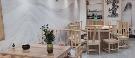 A traditional wooden dining area with a table, chairs, and a vase of flowers.