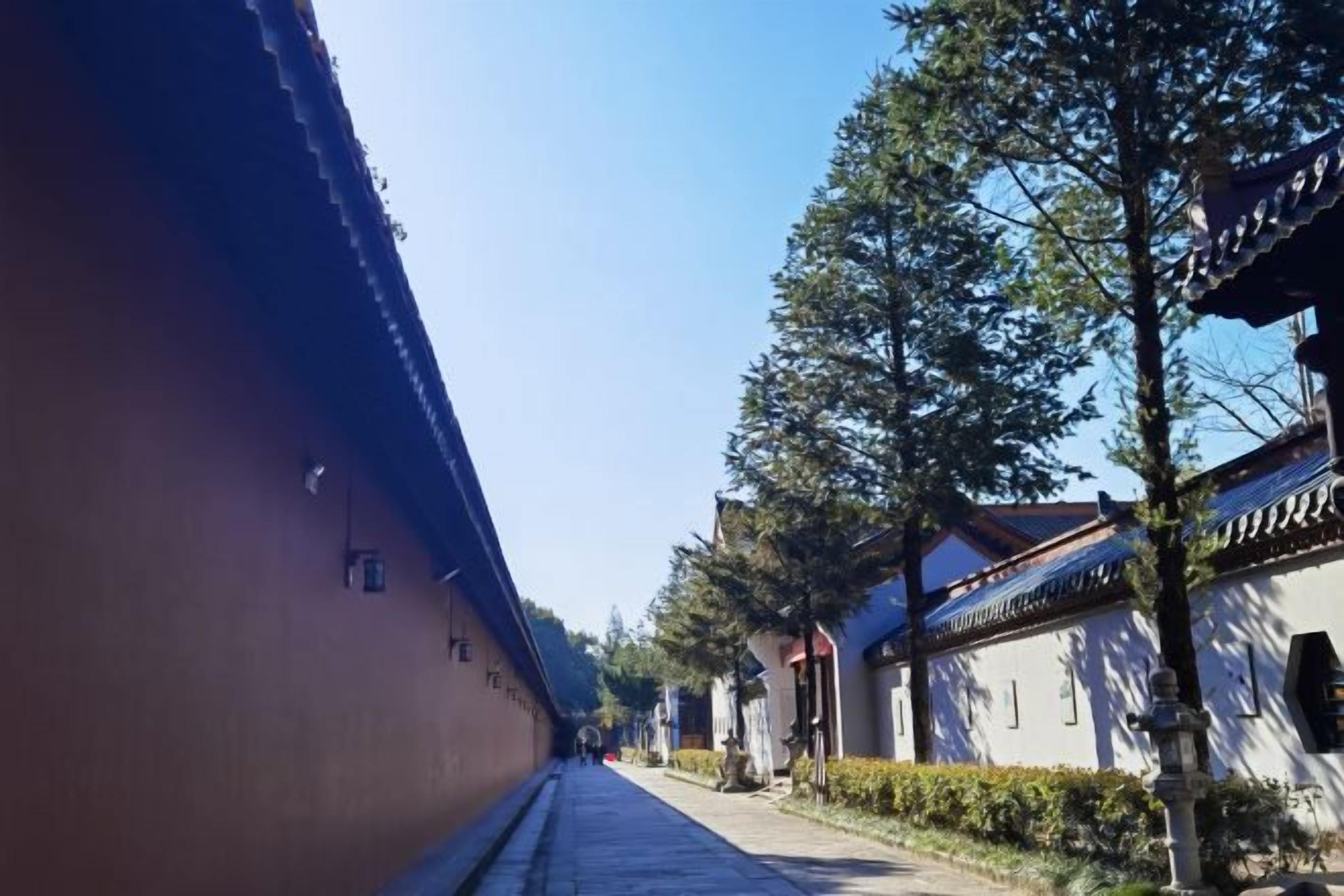 Un sendero estrecho bordeado por edificios tradicionales, con un cielo despejado arriba.