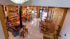 A spacious indoor area with wooden furniture, a large umbrella, and shelves with various items. - Hengyang Hengyue residence·Homestay (Nanyue Damiao Branch) (Hengyang)
