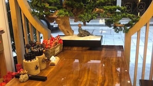 A polished wooden counter with decorative items and a small bonsai tree. - Hengyang Hengyue residence·Homestay (Nanyue Damiao Branch) (Hengyang)