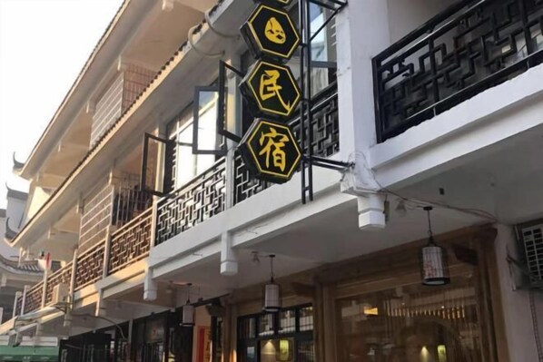Un edificio tradicional con varios balcones y un letrero que indica una casa de huéspedes.