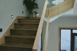 A wooden staircase with a glass railing leading to a room with a large window. - Hengyang Hengyue residence·Homestay (Nanyue Damiao Branch) (Hengyang)