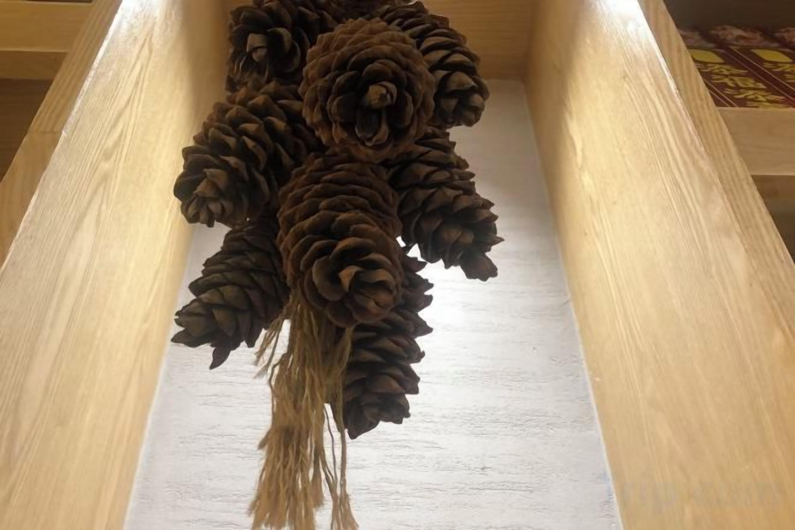 A wooden structure with a series of pine cones arranged in a decorative pattern.