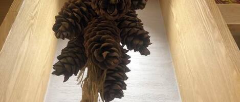 Une structure en bois ornée d’une série de pommes de pin disposées selon un motif décoratif.