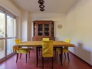 Un coin repas comprenant une table, des chaises, un buffet et une horloge murale.