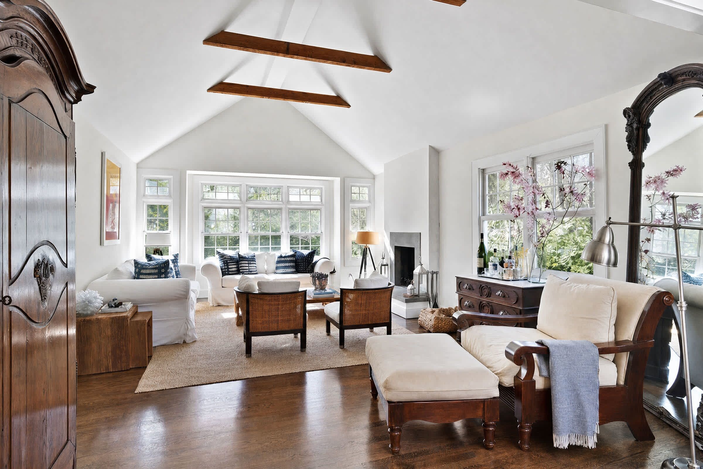 Un salon spacieux avec un haut plafond, de grandes fenêtres et une cheminée.