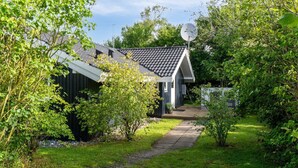 Moderni talo, jossa on kalteva katto, satelliittiantenni ja polku, joka johtaa sisäänkäynnille.
