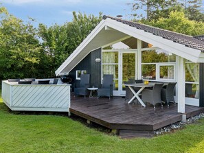 En mysig uteplats med en matplats, en grill och en liten sittgrupp.