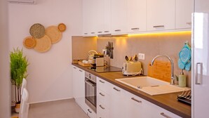 Eine moderne Küche mit weißen Schränken, einer Holzauskładfläche und einem eingebauten Backofen.