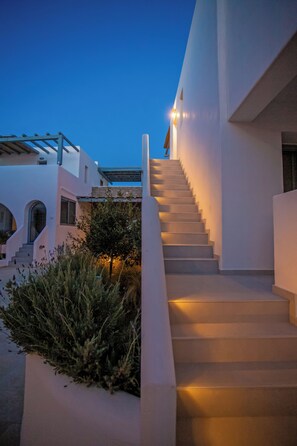 A modern building with a staircase leading to a second floor, surrounded by white walls and greenery. - Colors of Mykonos, Ano Mera, lovely apartment. (Mykonos)