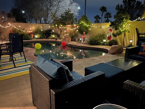 Zona de piscina al aire libre con sillones de descanso y una piscina pequeña.