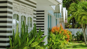 A building with striped exterior walls and large windows. - RIA ULUWATU Tropical Chic Hotel (Pecatu)