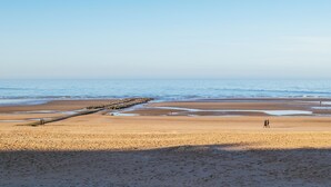 A beach with a rocky breakwater, sandy shore, and calm sea. - Cosy family flat centrally located (Koksijde)