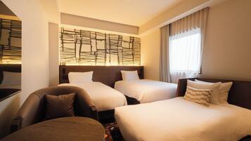 A hotel room with two beds, a sofa, a round table, and a decorative wall panel.