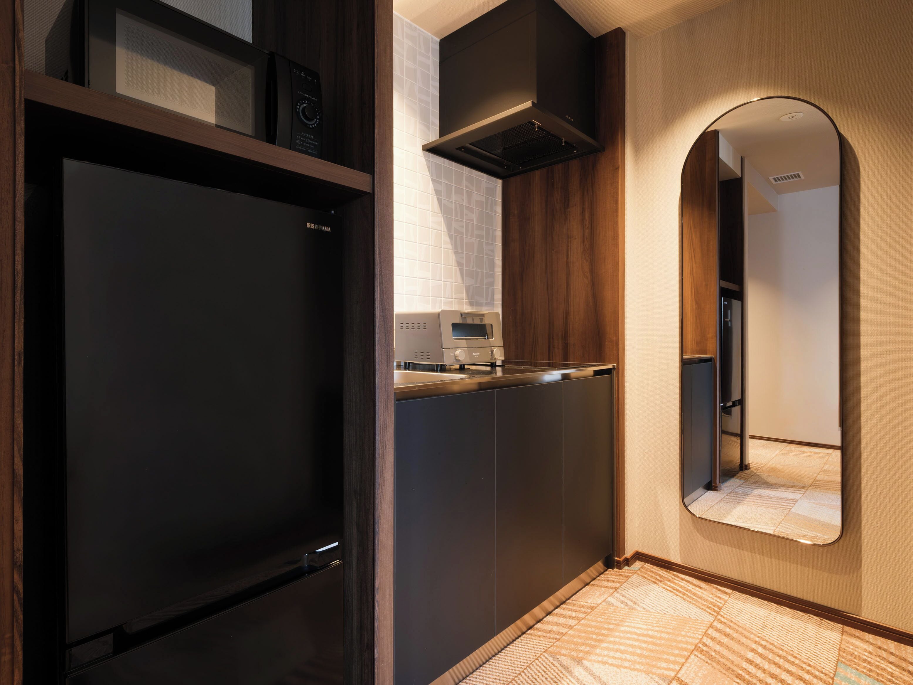 A modern kitchen with a built-in oven, microwave, and a range hood.