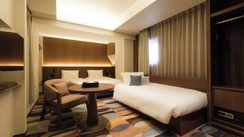 Habitación de hotel con cama, escritorio, silla, mesa redonda y televisor.