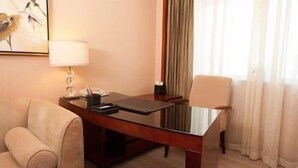A hotel room with a wooden desk, a lamp, a chair, and a bed. - JI Hotel (Dalian Donggang International Convention Center) (Dalian)