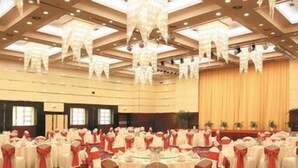 A large hall with round tables, red sashes, and a high ceiling with chandeliers. - JI Hotel (Dalian Donggang International Convention Center) (Dalian)