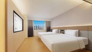 A hotel room with two beds, a city view, and a framed picture on the wall. - JI Hotel (Dalian Donggang International Convention Center) (Dalian)