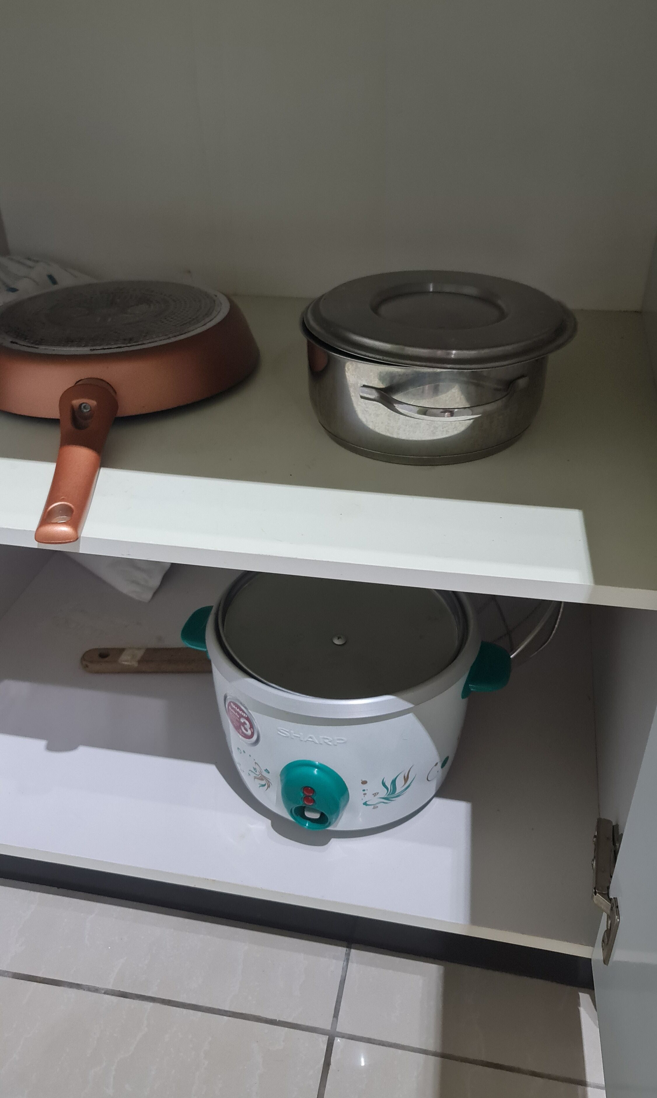 A kitchen with a white countertop, a copper pan, and a white electric stove.