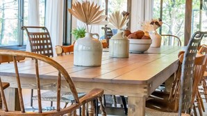 Un comedor con una mesa de madera, sillas y jarrones decorativos.