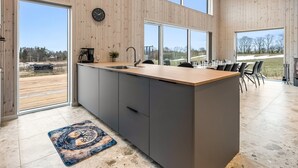 A modern kitchen with a central island, large windows, and a view of the outdoors. - "Gillis" - 1km from the sea by Interhome (Glesborg)