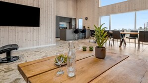 A modern interior with a wooden floor, a large table with a plant, a wine glass, and a bottle. - "Gillis" - 1km from the sea by Interhome (Glesborg)