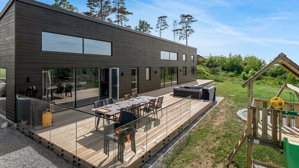 A modern building with a deck, outdoor seating, and a play area. - "Gillis" - 1km from the sea by Interhome (Glesborg)